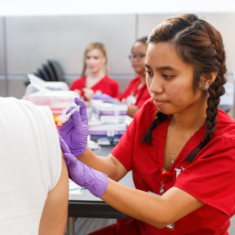 A nursing student giving a vaccination.